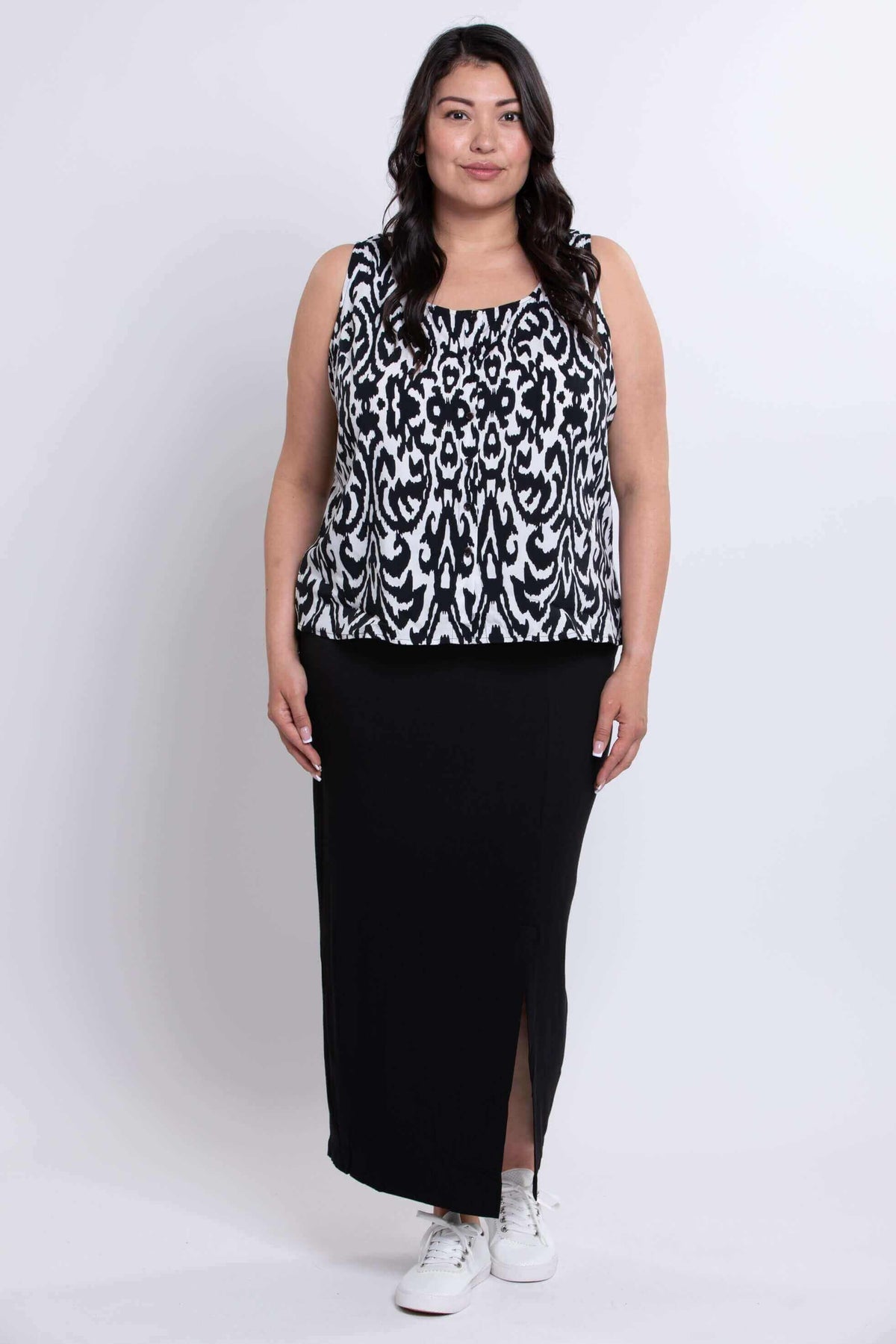 Full body view of model in sleeveless black and white Ikat tank paired with a black skirt