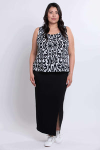 Full body view of model in sleeveless black and white Ikat tank paired with a black skirt