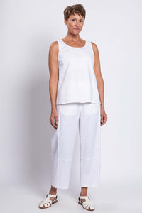Woman standing in a white sleeveless tank and matching pants, full outfit