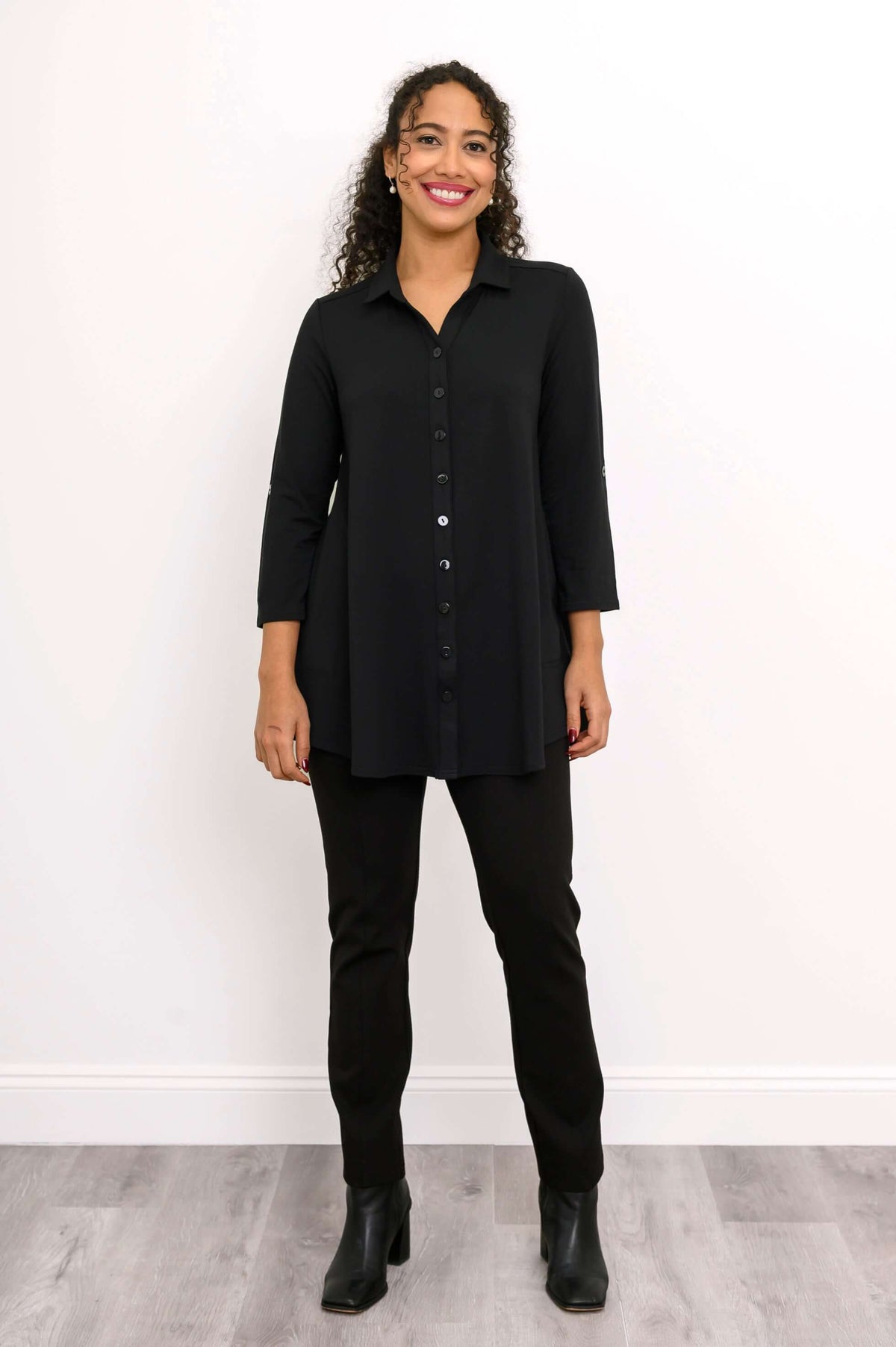 Full view of woman in black blouse-jacket and pants with boots