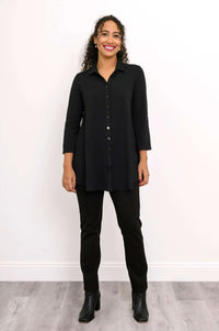 Full view of woman in black blouse-jacket and pants with boots
