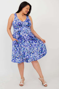 Model twirling in Genesis blue floral dress, showing flowy skirt