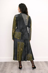 Back view of a model wearing a matching patterned long-sleeve top and relaxed midi skirt set from behind.