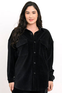 Front view of a woman wearing a black button-up corduroy shirt jacket with double flap pockets