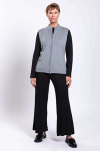 Woman in a gray zip-up vest, black wide-leg pants, and black shoes, facing forward