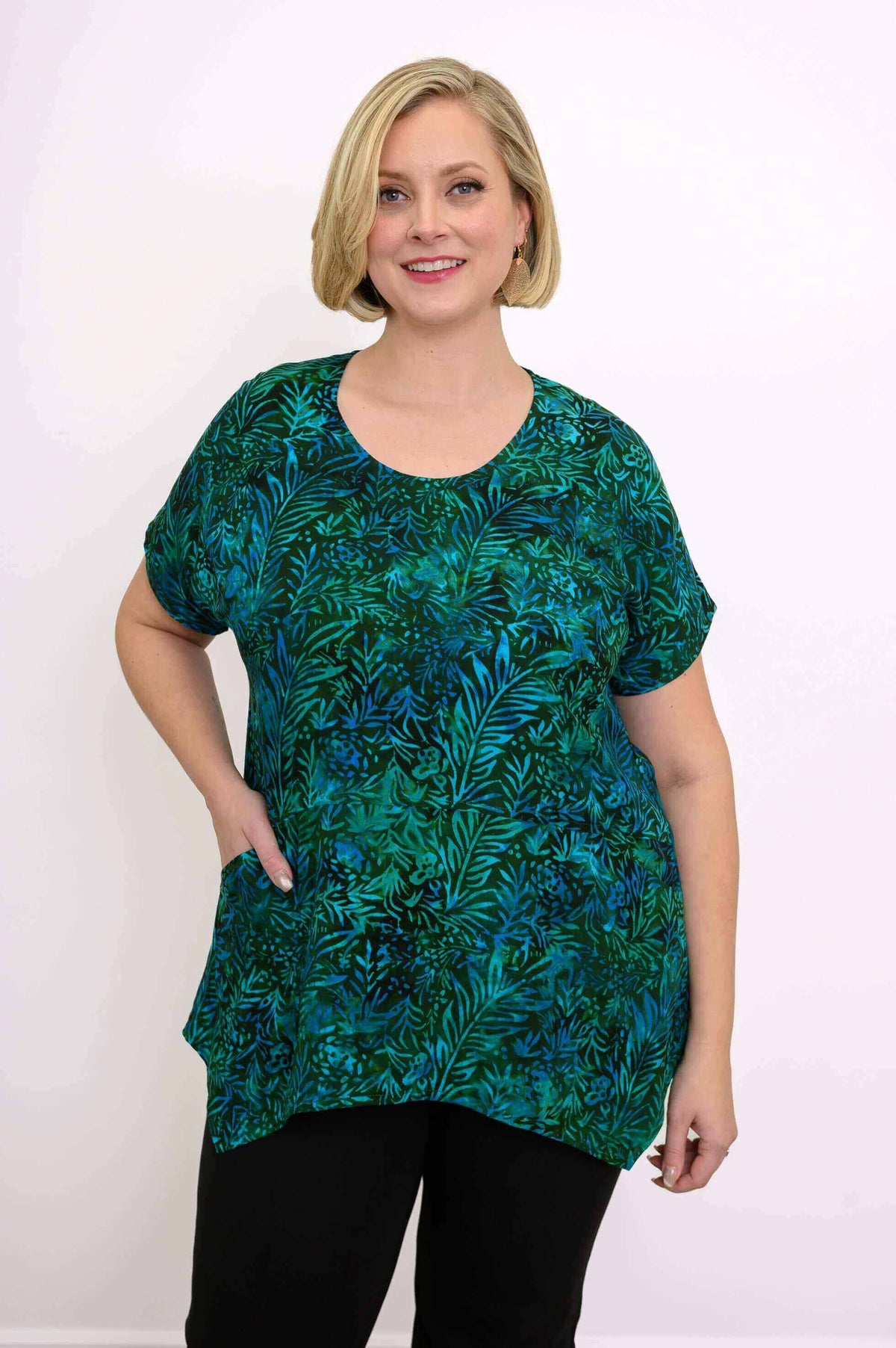Woman wearing green and blue leafy print tunic top with relaxed fit and round neckline