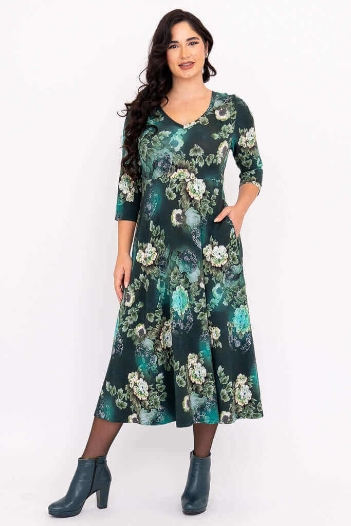 Woman wearing a green floral midi dress with V-neck and three-quarter sleeves, front view