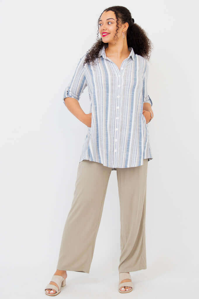 Model with hands in pockets, wearing striped tunic shirt and beige pants