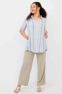 Model with hands in pockets, wearing striped tunic shirt and beige pants