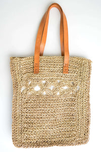Handwoven rattan tote bag with leather handles and floral crochet detail