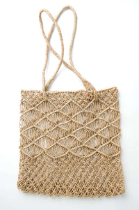 Handwoven rattan tote bag with wave pattern and long handles on white background