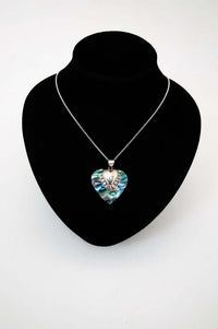 Heart-shaped abalone and silver pendant necklace displayed on a black bust