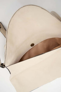 Inside look of ivory crossbody bag with flap open and magnetic closure
