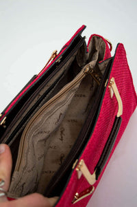 Interior compartments and zipper pockets of crimson satchel bag with branded lining