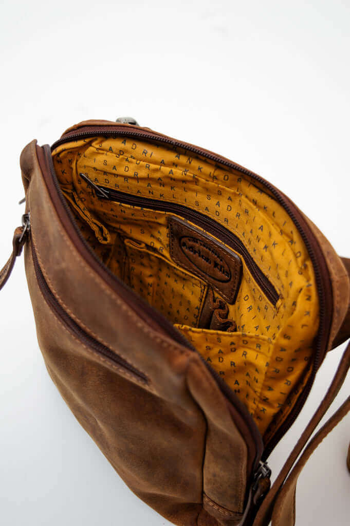 Open view of the crossbody bag displaying interior zip pocket and yellow branded lining
