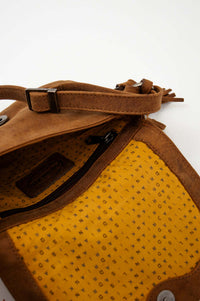 Interior view of crossbody bag showing yellow fabric lining and inner compartments