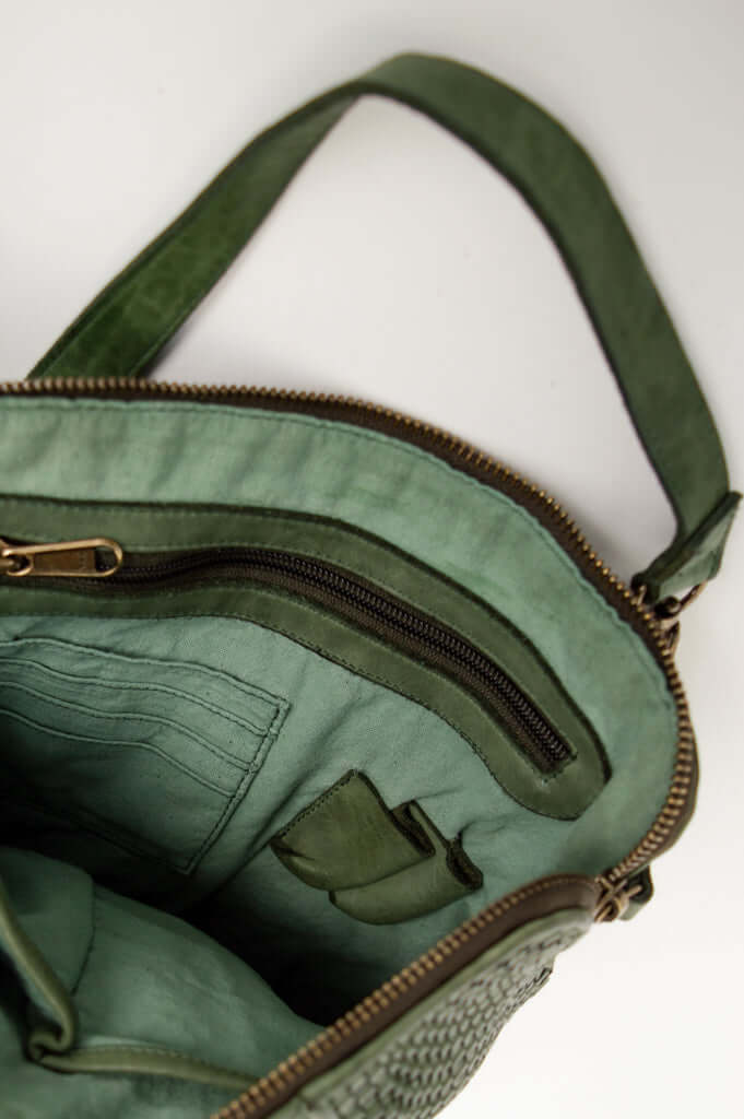 Interior view of green leather bag showing zipper pocket and card slots