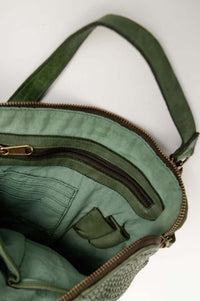 Interior view of green leather bag showing zipper pocket and card slots