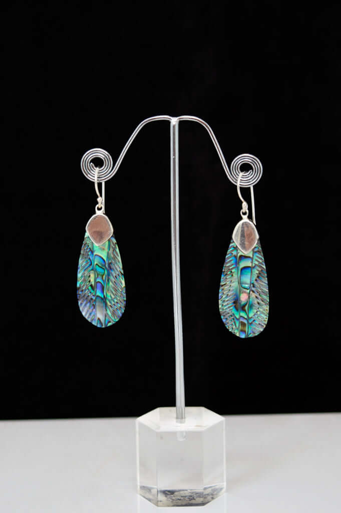 Pair of iridescent abalone drop earrings with 925 sterling silver setting displayed on a stand