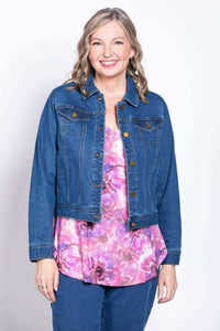 Woman wearing a denim jacket over a pink floral V-neck bamboo top and jeans