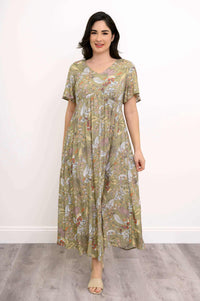 Woman in a floral empire waist maxi dress standing on a light wooden floor