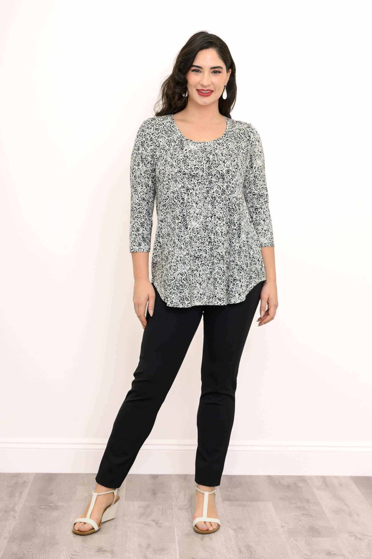 Woman in jazz bamboo rose swirl top standing and smiling