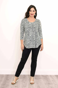 Woman in jazz bamboo rose swirl top standing and smiling