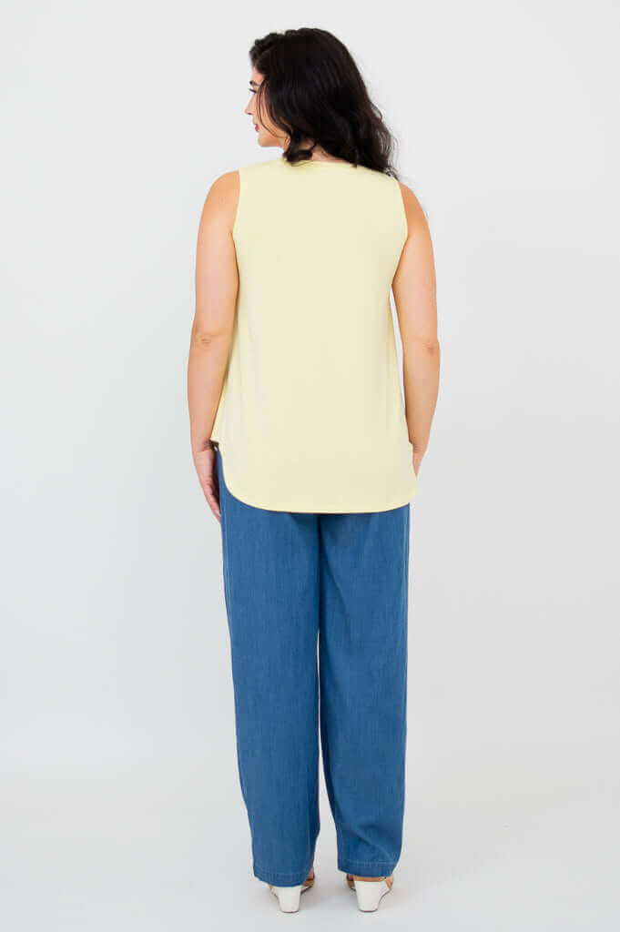 Back view of model in lemon bamboo tank top paired with loose blue pants
