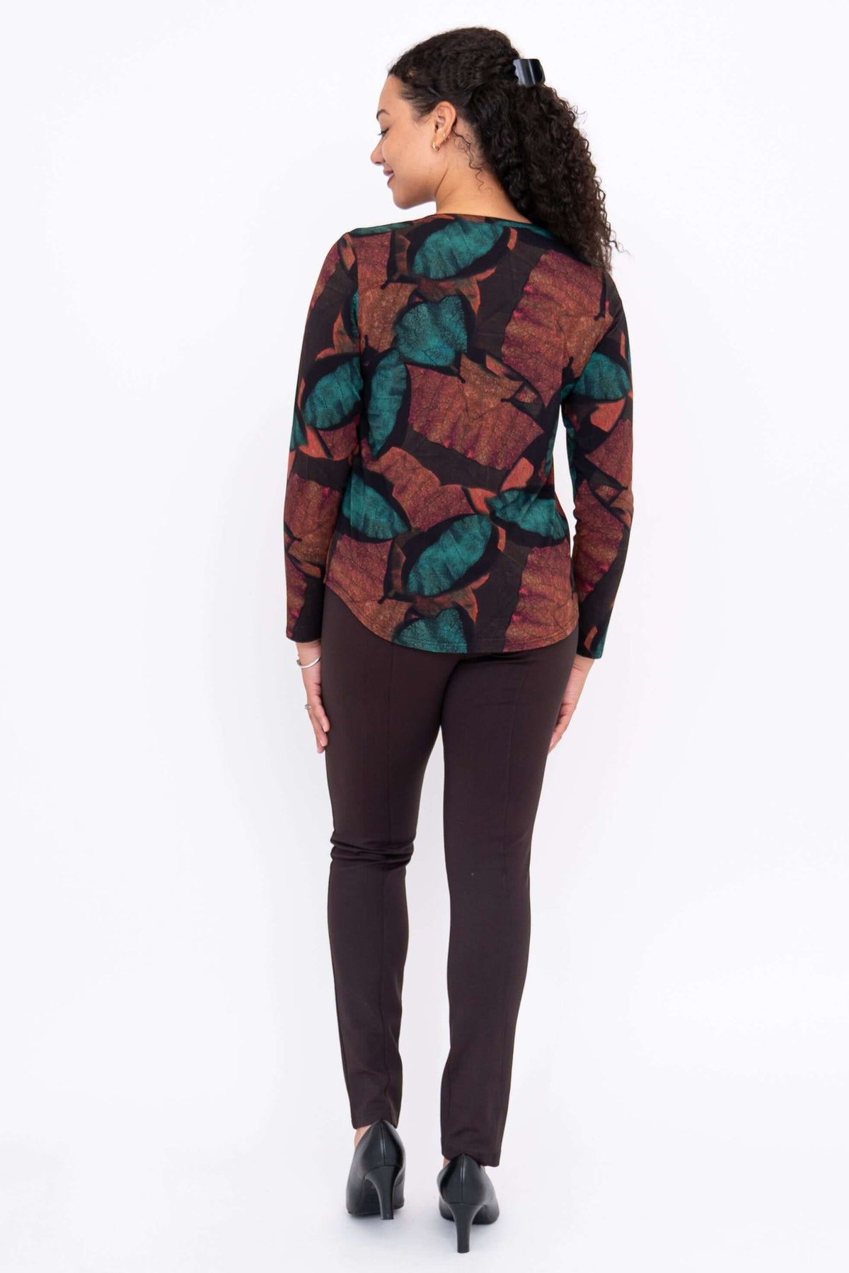 Back view of model wearing Jazz bamboo top with teal and rust leaf print