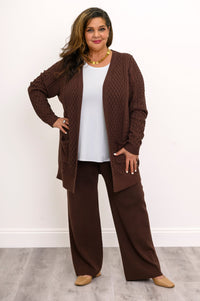 Hip length dark brown open front cardigan styled with a monochrome earth tone trousers outfit.