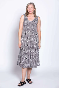 Woman posing in sleeveless black and white tiered dress with side pockets