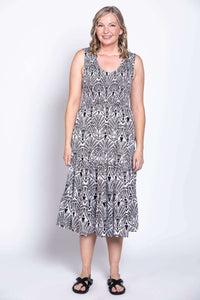 Woman standing front-facing in black and white scoop neck tiered dress