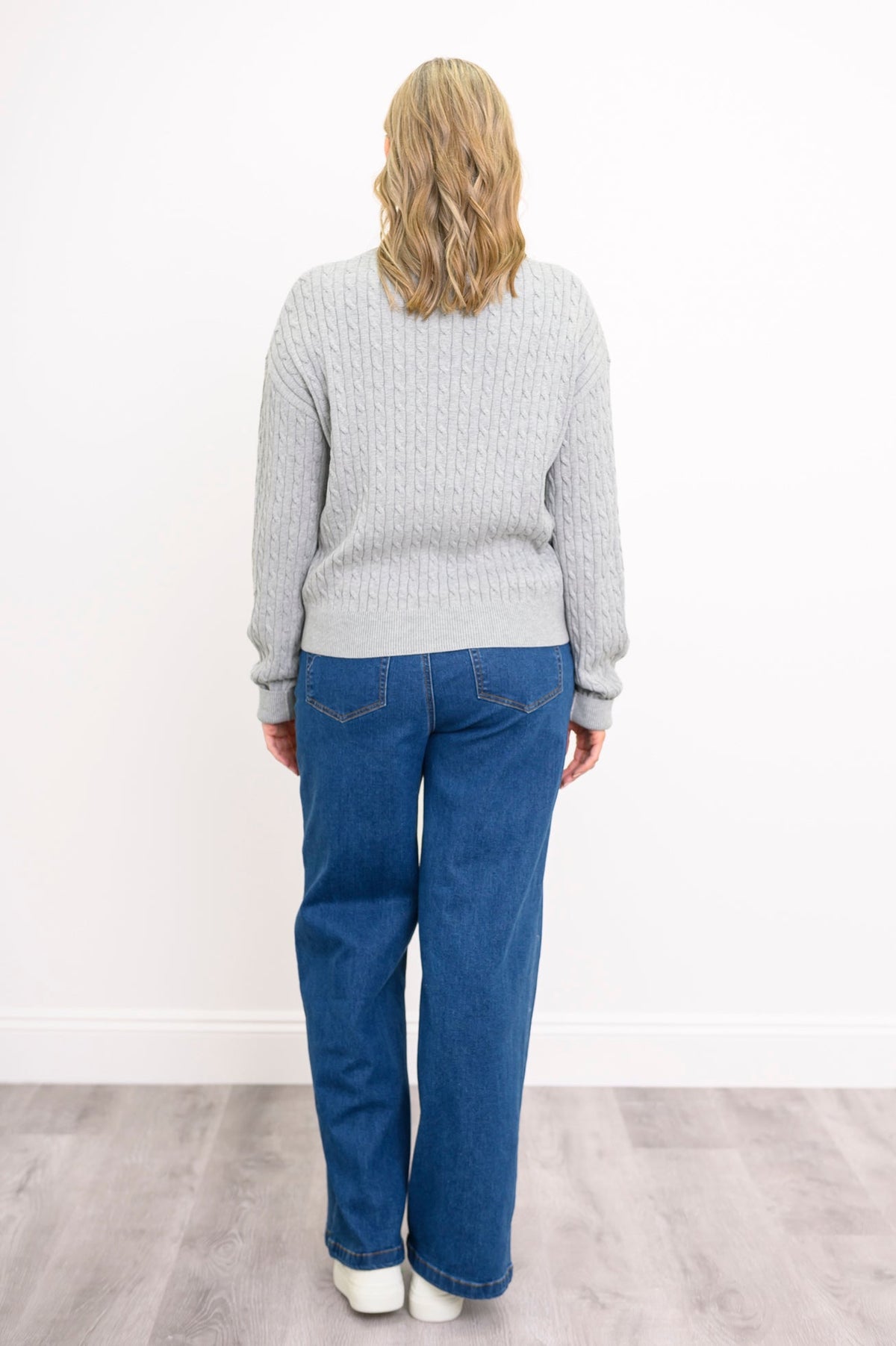 Back view of a women's silver-toned long-sleeve pullover top, showcasing a loose and comfortable frame.