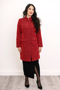 Slightly angled view of woman in textured wool coat and black skirt with slit detail