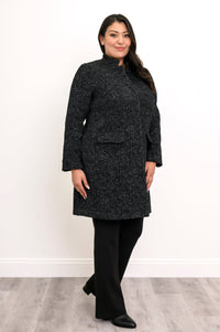 Side view of woman wearing long black coat with mandarin collar and flap pockets