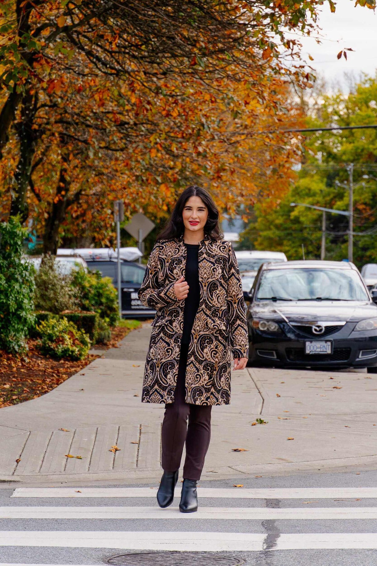 Woman crossing street in Julia Coat, styled with black pants and ankle boots