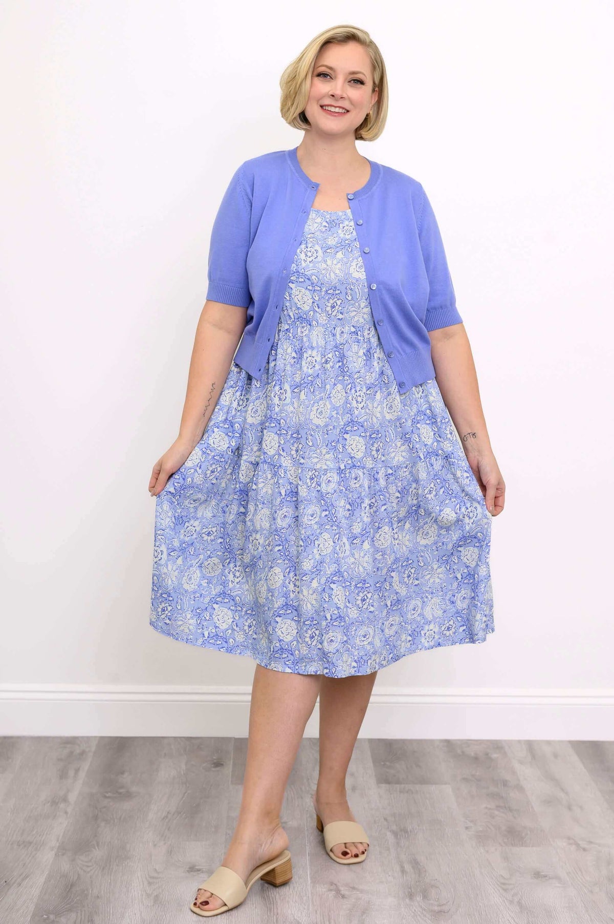 Front view of the Juni Dress in blue floral with lavender cardigan
