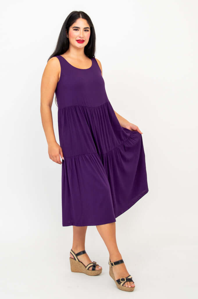 Woman in plum dress showcasing flowy tiered skirt