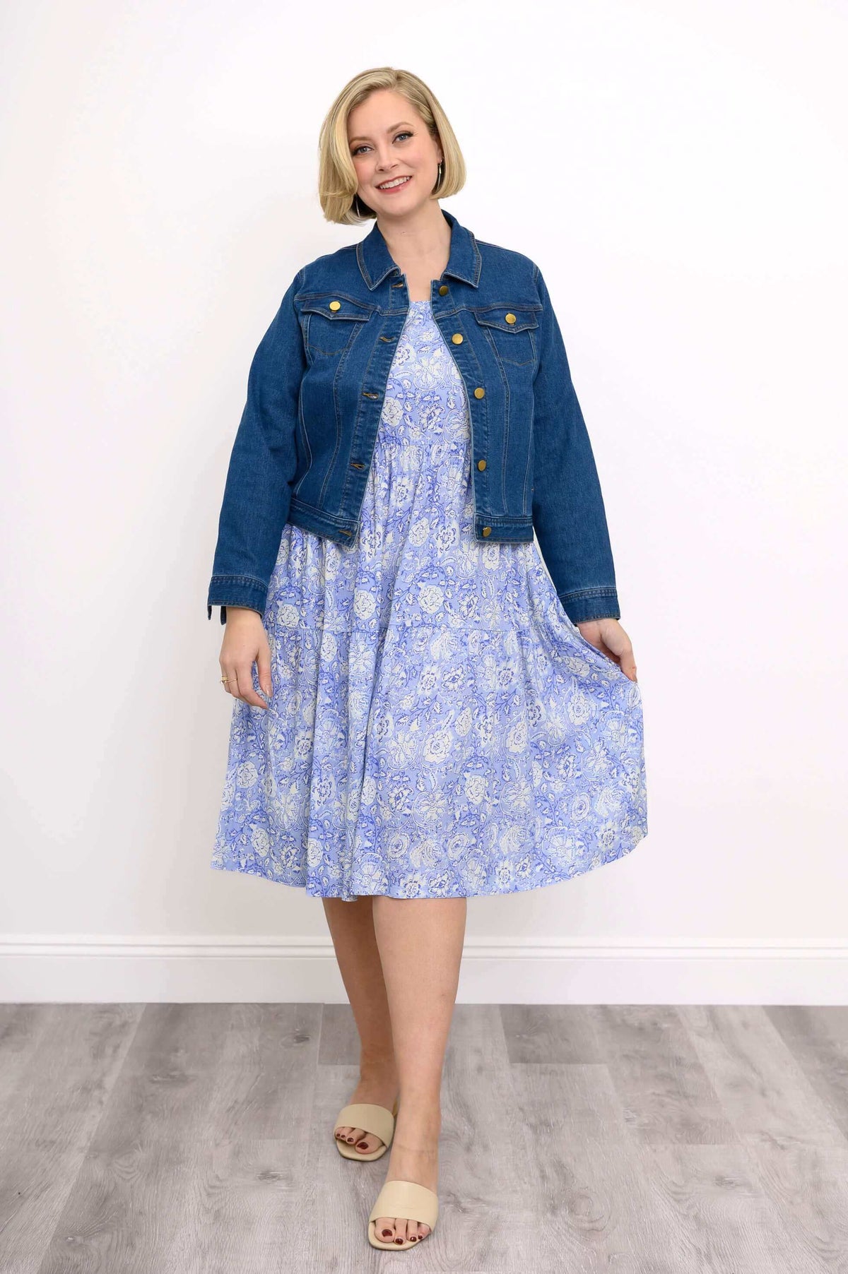 Woman styling the Juni Dress with a denim jacket and beige sandals