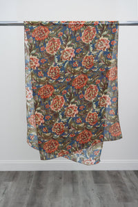 A large teal silk scarf with an orange and green floral print displayed on a metal rod against a white background, front view