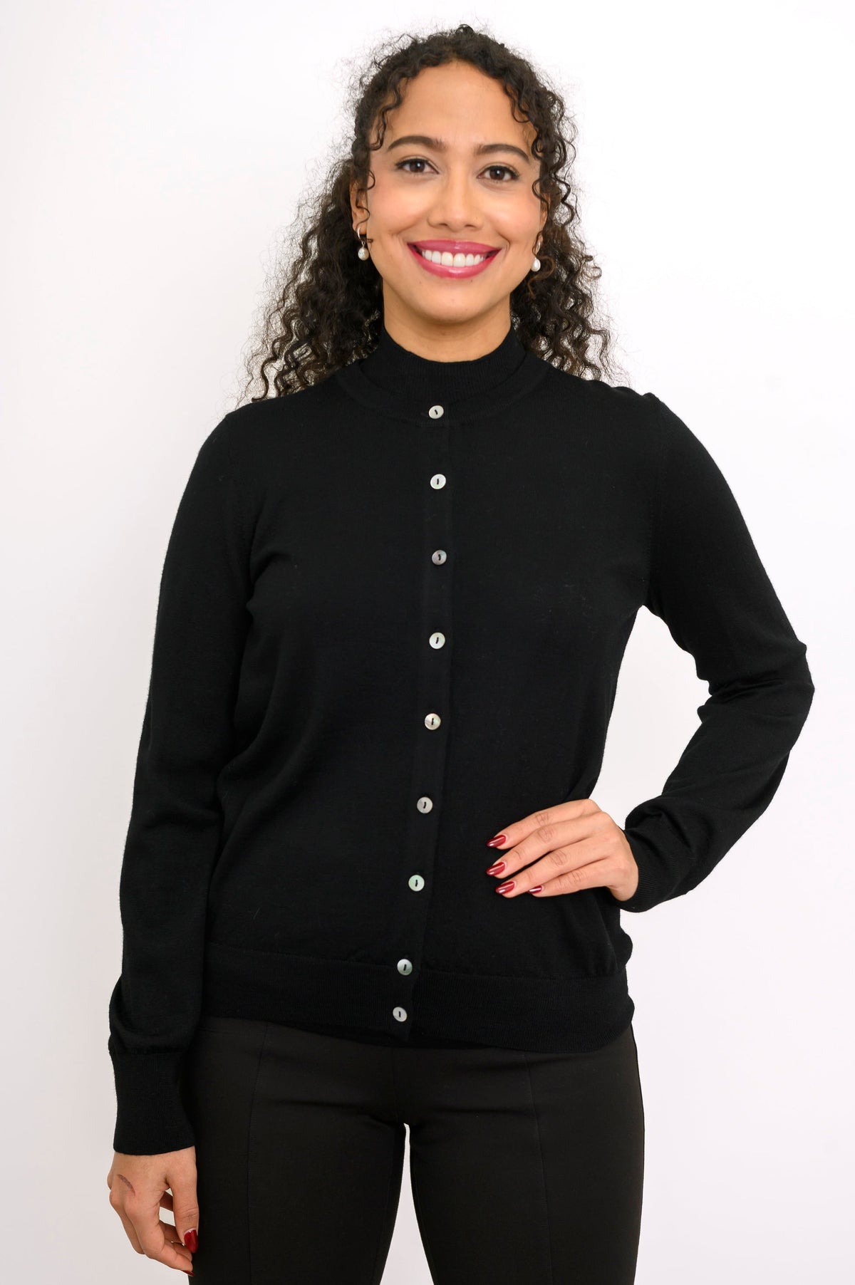 Studio portrait of a model in a black long sleeve button down wool cardigan sweater with ribbed trim.
