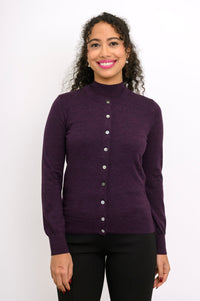 Front view of woman wearing a purple cardigan on a purple top and black pants against a white background