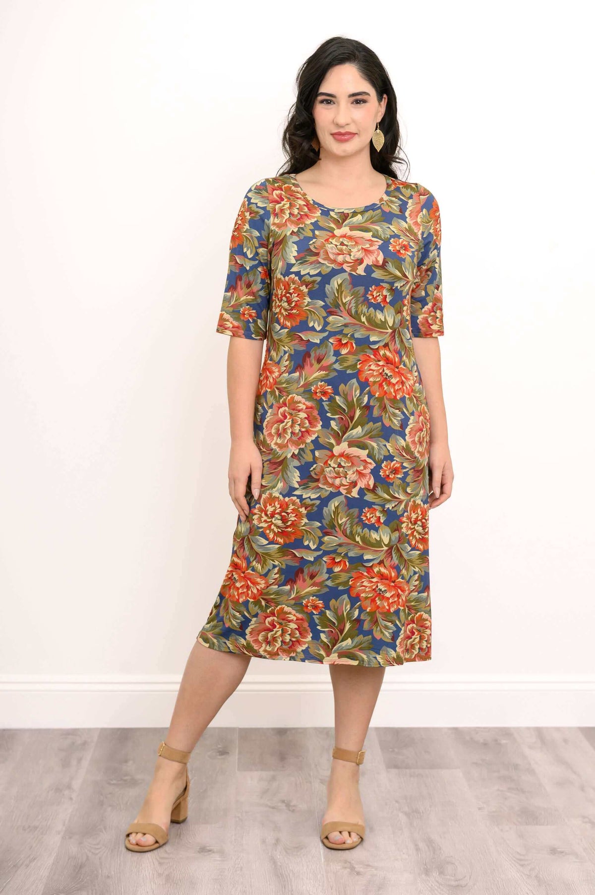 Woman modeling a knee-length floral bamboo dress with 3/4 sleeves, standing pose