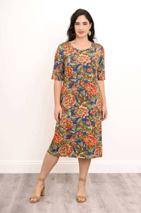 Woman modeling a knee-length floral bamboo dress with 3/4 sleeves, standing pose