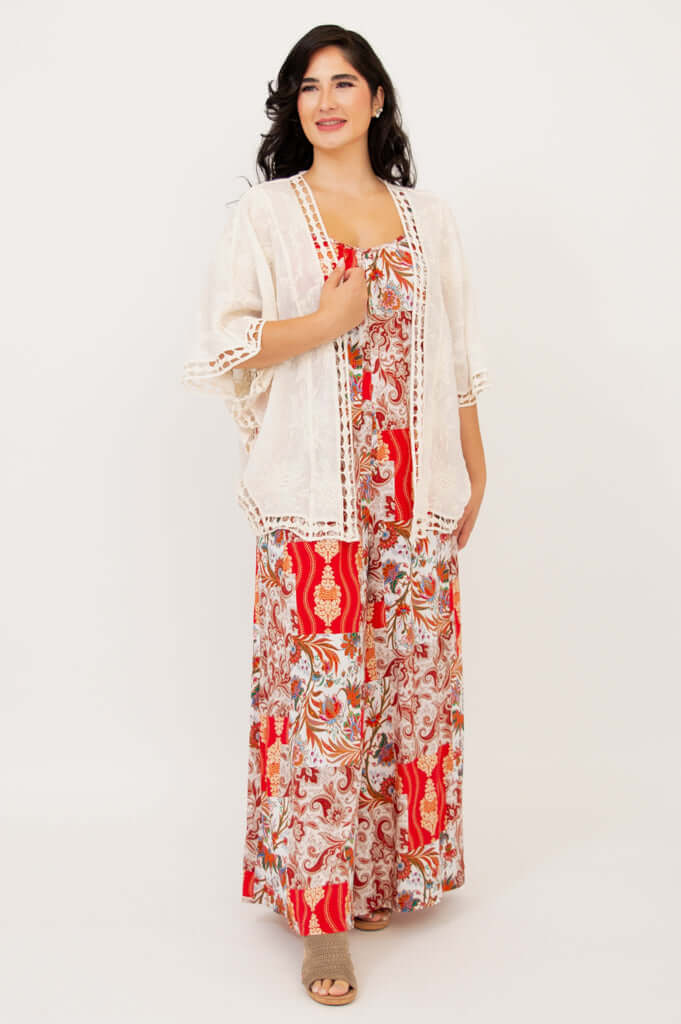 Woman posing in a lace boho kimono cardigan paired with a red patterned maxi dress