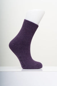 Cozy eggplant purple merino wool knit crew sock displayed on a mannequin foot with a clean white background.