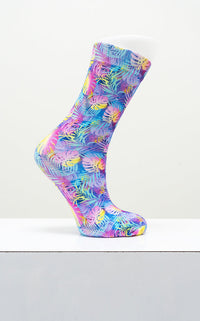 Vibrant multi color tropical palm leaves patterned dress sock shown on a white display mannequin foot model.
