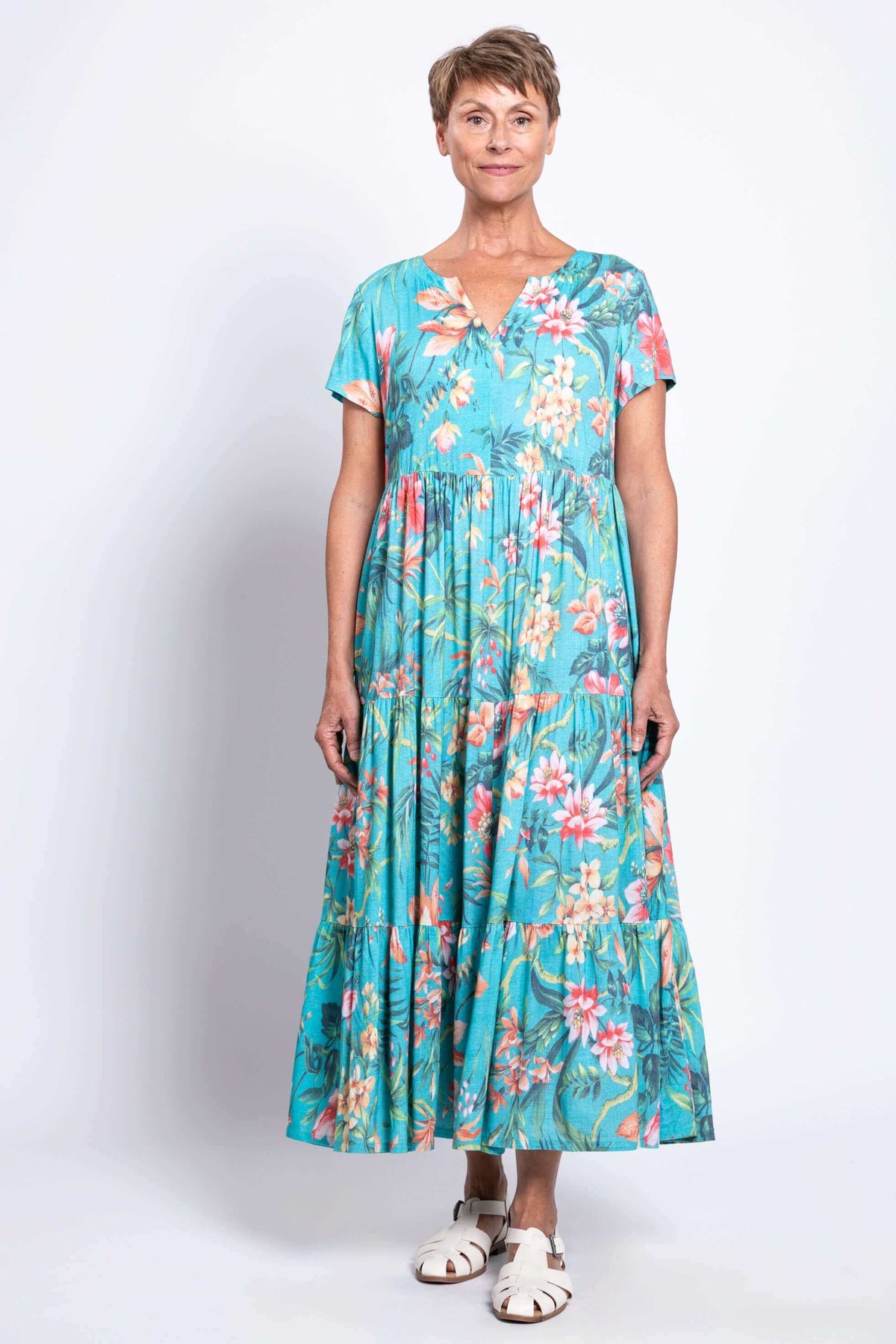Full front view of a woman in a tiered, blue floral Laurita maxi dress