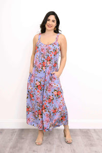 Woman wearing a lavender floral maxi dress with pockets, standing and smiling