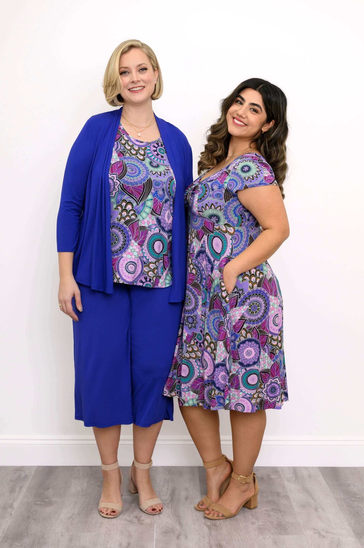 Two models wearing matching violet medallion outfits, one in Lavon dress, one in top and pants